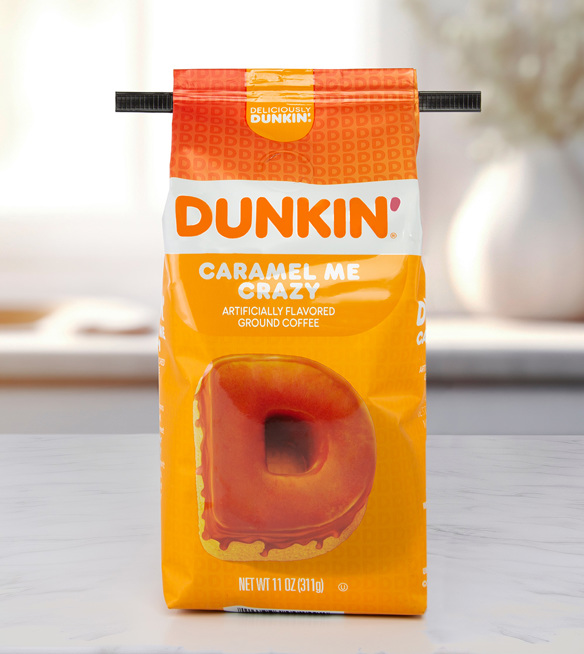 A black coffee bag tie on an orange Dunkin' brand Caramel Me Crazy coffee bag.