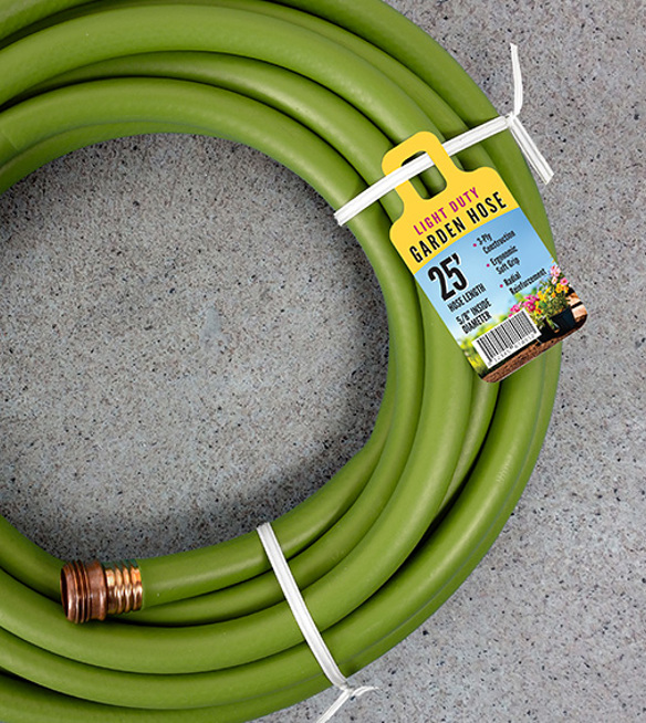 A tag advertising a 25' garden hose attached to a white twist tie securing a green garden hose. 