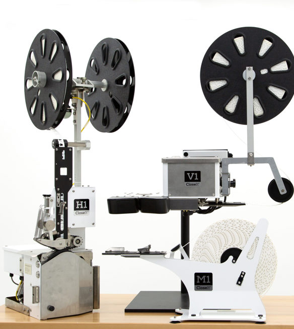 3 bag closure machines with reels of closet bag clips attached. 