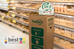 A TagBack branded cardboard drop box with instructions how to return ties and tags against a background in a retail baking aisle. Bottom left features IBIE best in baking logo.