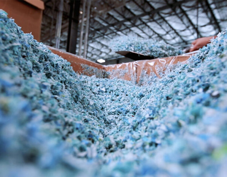 A mass of blue and white plastic that has been ground up to be recycled.