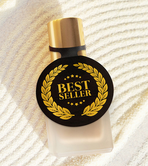 A perfume bottle with circular black elastic label with "Best Seller" and golden wheat decorative border. 