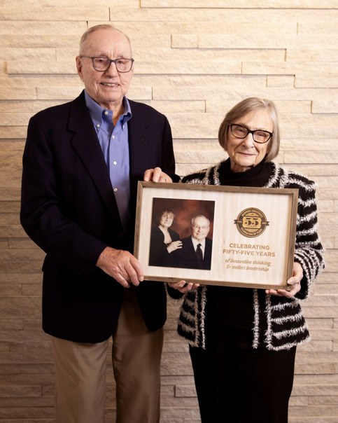 Bob and Patricia Ludlow hold a commemorative Bedford Industries anniversary plaque celebrating decades of leadership and innovation.