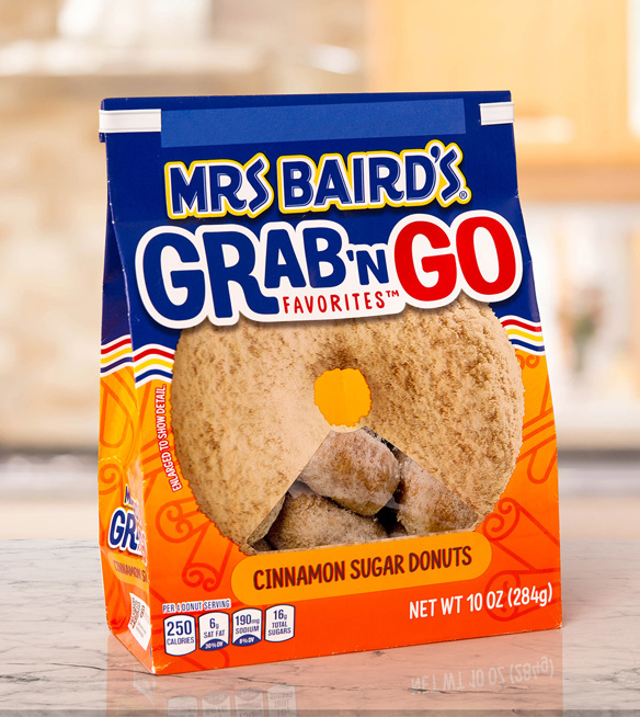 A white donut bag closure on a Mrs. Baird's brand mini cinnamon sugar flavor donuts.