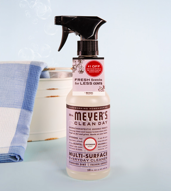 Mrs. Meyer's Clean Day lavender multi-surface cleaner spray bottle featuring a $1 off ElastiTag coupon on a blue countertop.