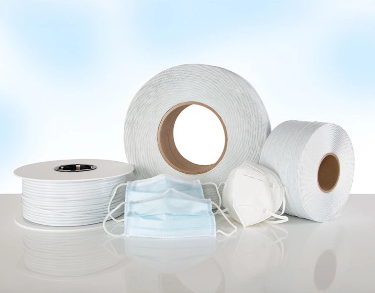 White, plastic-coated medical wire wound on 3 spools and 3 medical face masks with face mask nose wire in front.
