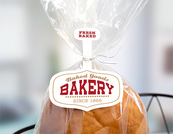 Loaf of bread in clear plastic bag with "Fresh Baked" and "Baked Goods Bakery Since 1966" tag attached to the bag by a white twist tie. 