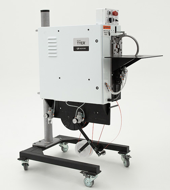 white machine that applies twist ties to secure hoses and cords.