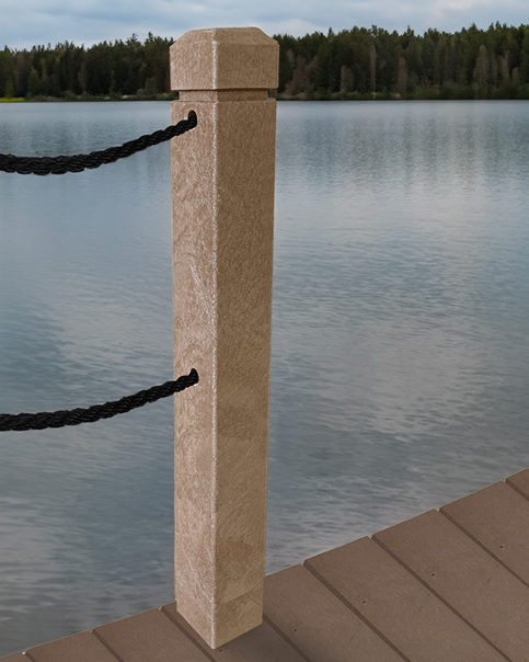 Tan bollard on a wooden dock with black ropes, overlooking a calm lake and forested shoreline.