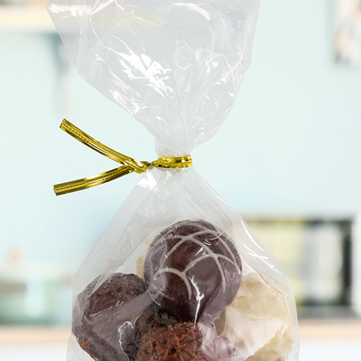 A gold metallic twist tie securing a bag of chocolate truffles. 
