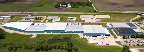 A slow-moving drone video of Bedford Industries’ blue manufacturing buildings.