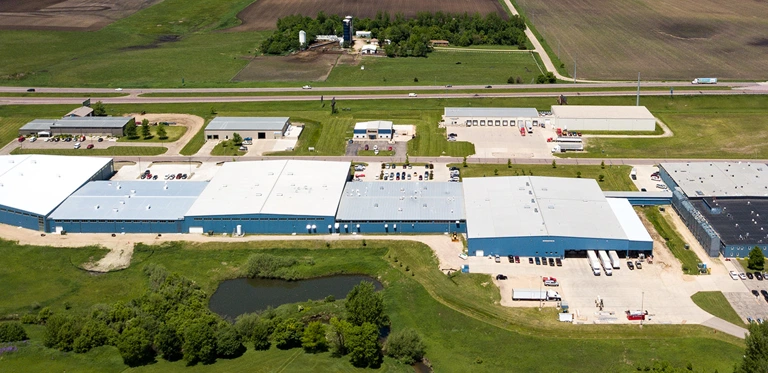 A slow-moving drone video of Bedford Industries’ blue manufacturing buildings.