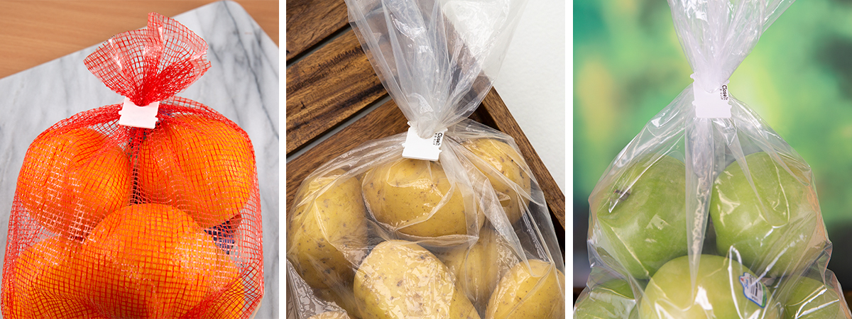 Bio-Clip Compostable bag clips on potatoes, oranges, and apples.