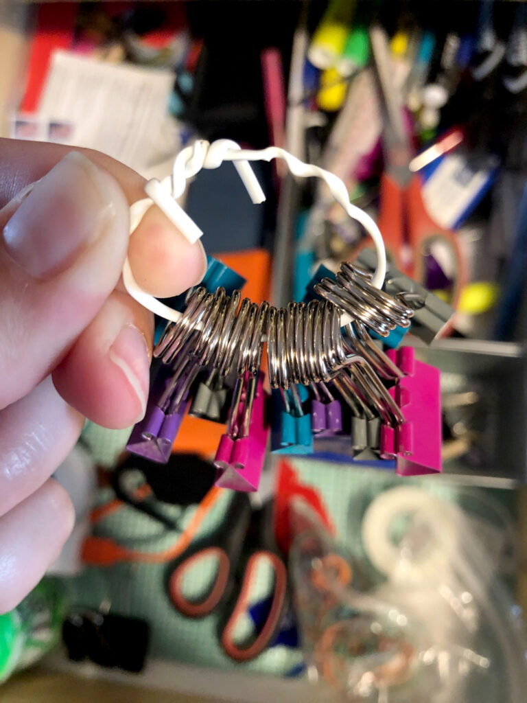 A white plastic wire tie holds document clips together