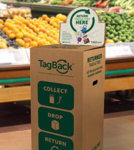 A tall cardboard box in grocery store with small deposit hole, TagBack logo, and instructions: “Return Tags & Ties Here”