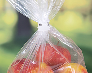 Bio-Clip_RedApples A compostable bag closure clip around a bag of red apples