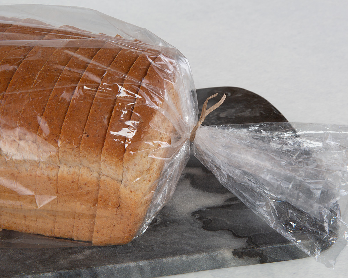 A tan, recycled paper twist tie on a loaf of bread