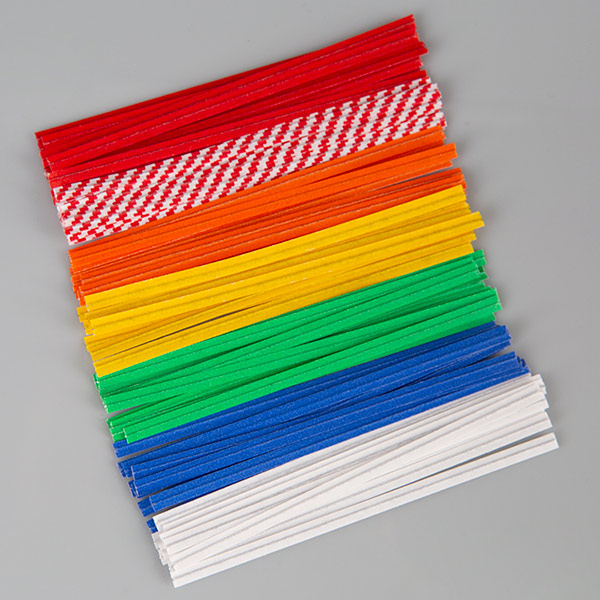 4in paper - standard colors2_LR A stack of colorful Bedford twist ties arranged in rows on a gray background. The twist ties are grouped by color, including red, red-and-white checkered, orange, yellow, green, blue, and white. Each tie is uniform in length, highlighting the variety of color options available for packaging use.