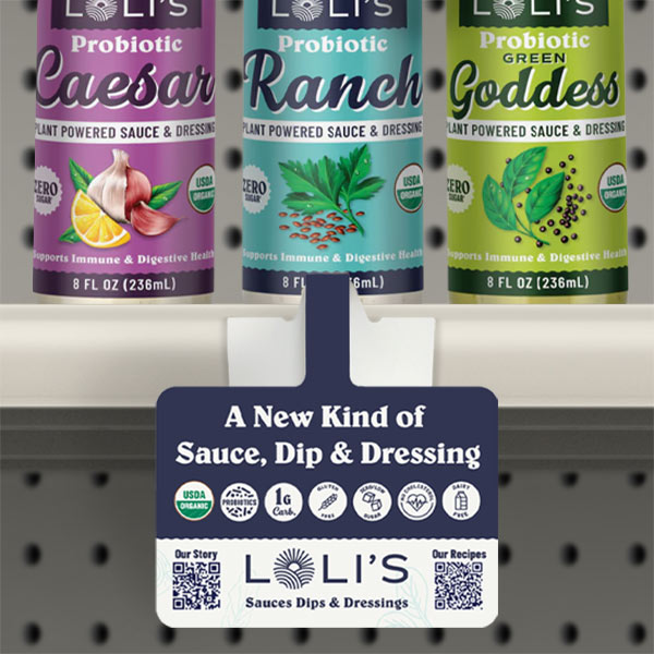 Lolis_ShelfTalker Three bottles of LOLI'S Probiotic Sauces and Dressings in flavors Caesar, Ranch, and Green Goddess, with a shelf talker below advertising them as a new kind of sauce, dip, and dressing.