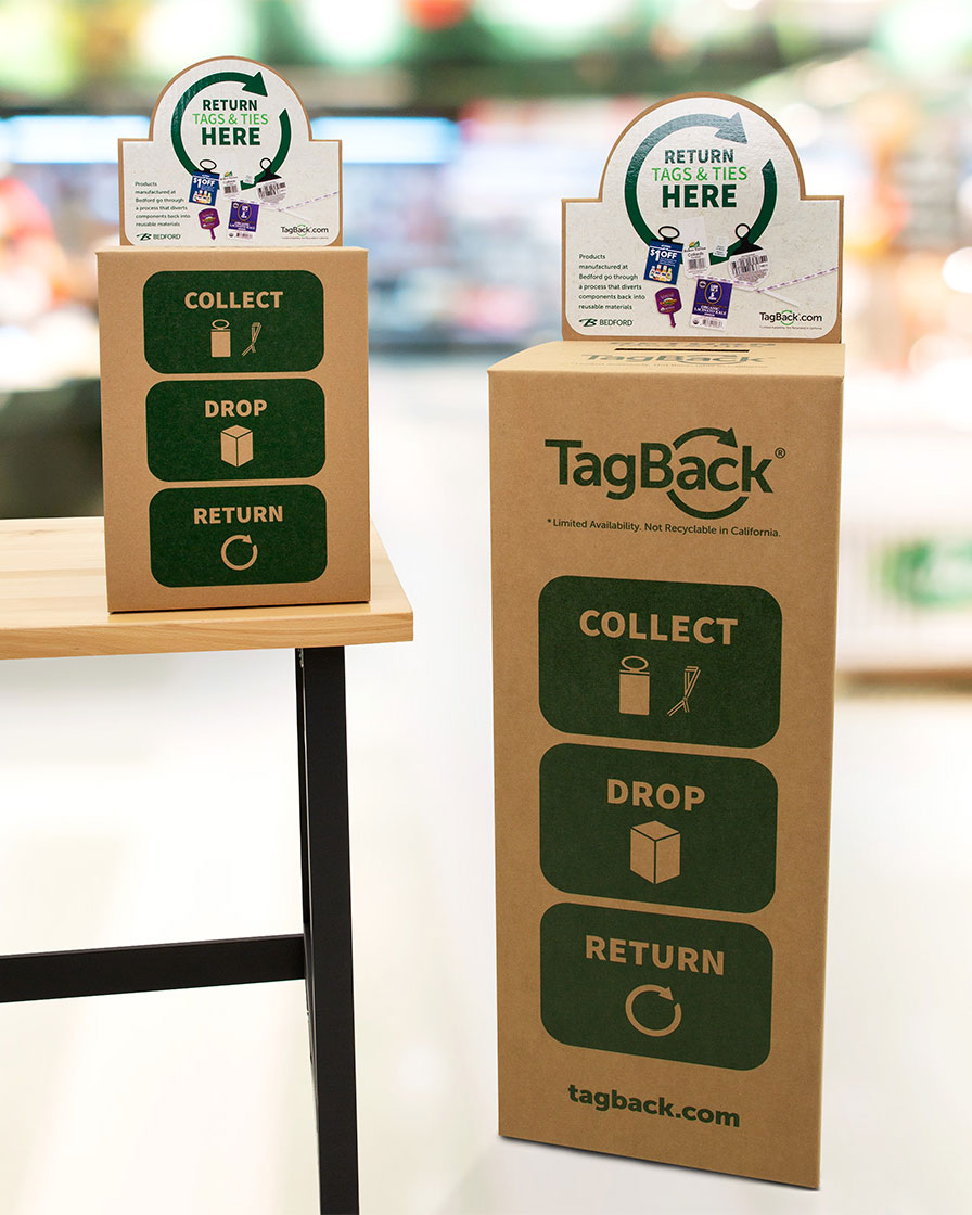 Two TagBack collection boxes, one mini on a table, and one standard taller one on the floor.